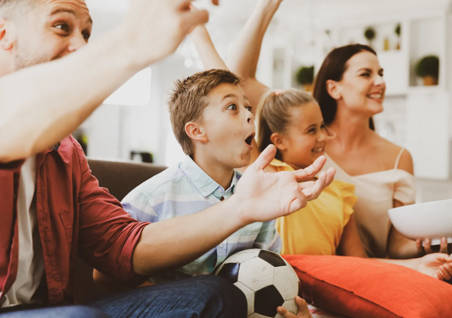excited caucasian parents couch with daughter son watching football match tv