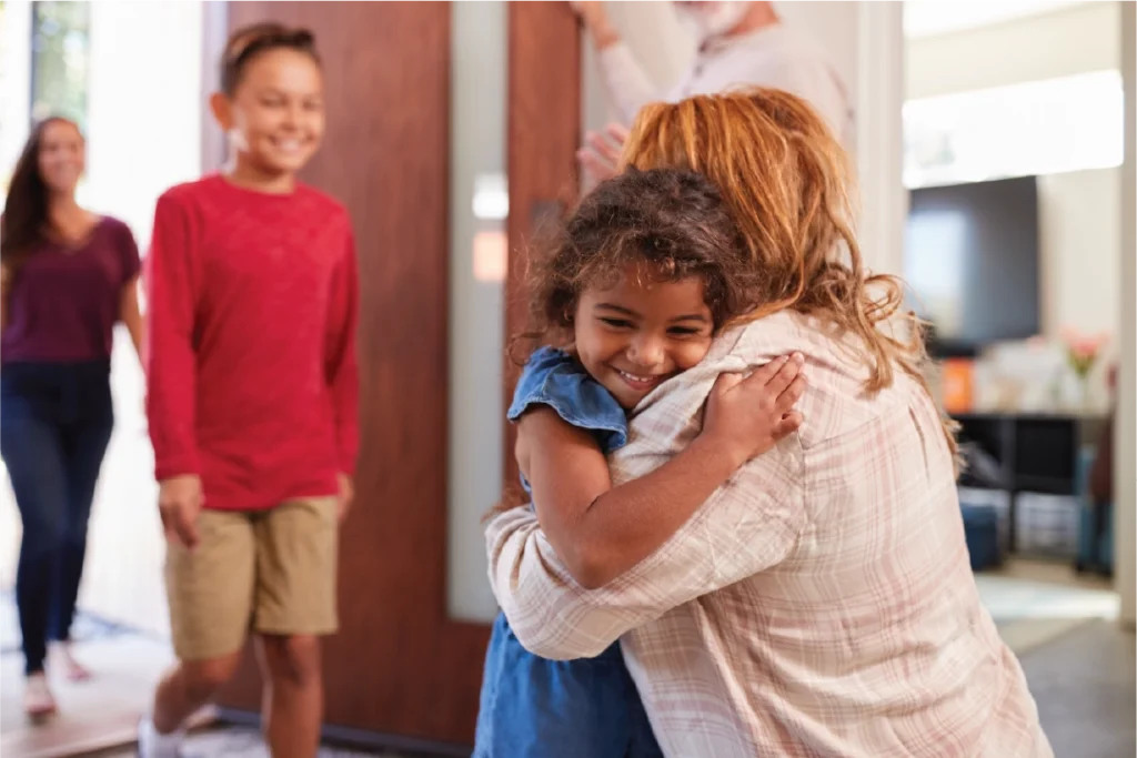 grandparents-greeting-grandchildren-front-door-as-they-comes-visit