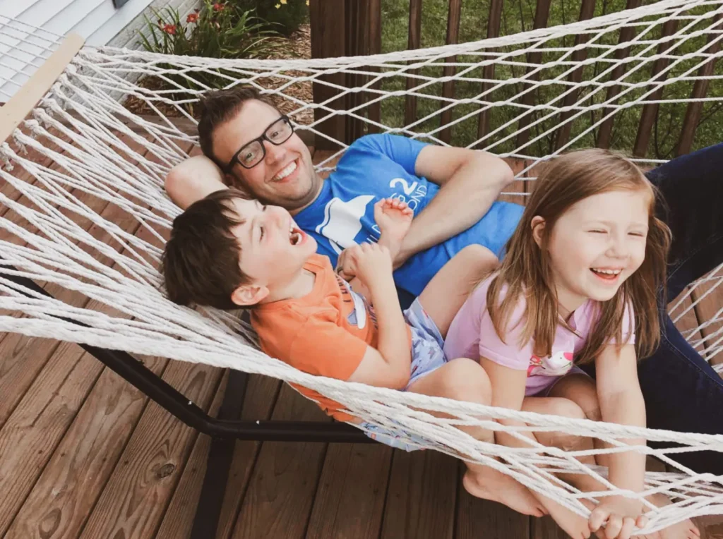 kids playing-with-their-dad-in-hammock