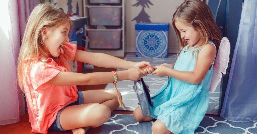 Siblings Arguing Again? 3 Tips to Decide If It's Time to Step In & Help Your Kids 3 siblings arguing - sisters fighting over a toy