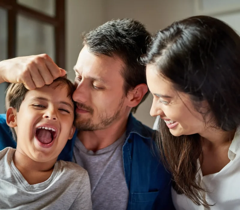 family-playful-bonding-home-with-mother-parents-son-together-love-smile-father-relax-with-mama-happy-child-house-bedroom-with-support-care-childhood-fun-growth-copy-scaled-1.webp